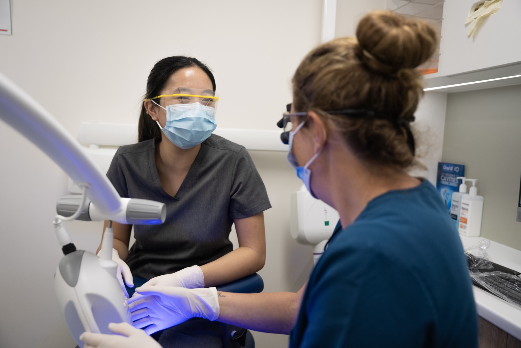 A clinician assessing a patient during veneer and smile treatment planning at Newtown Elite Dental